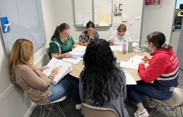 A group of teachers working in the office on professional learning.