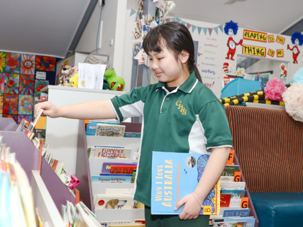 A student selecting a book from the library.