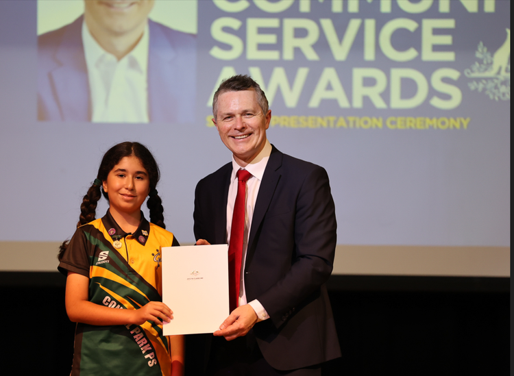 A student receiving an award from Jason Clare.