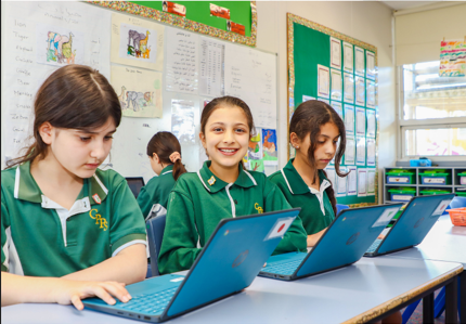 Students working on laptops in the classroom.